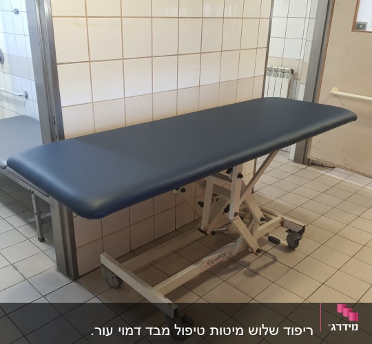 מיטת טיפול עם ריפוד כחול בחדר מרוצף